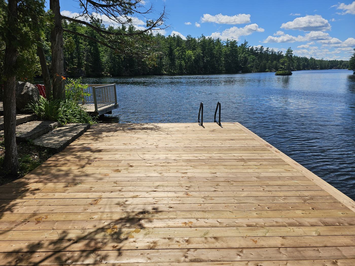 New wooden dock with swim ladder on a Kawartha lake